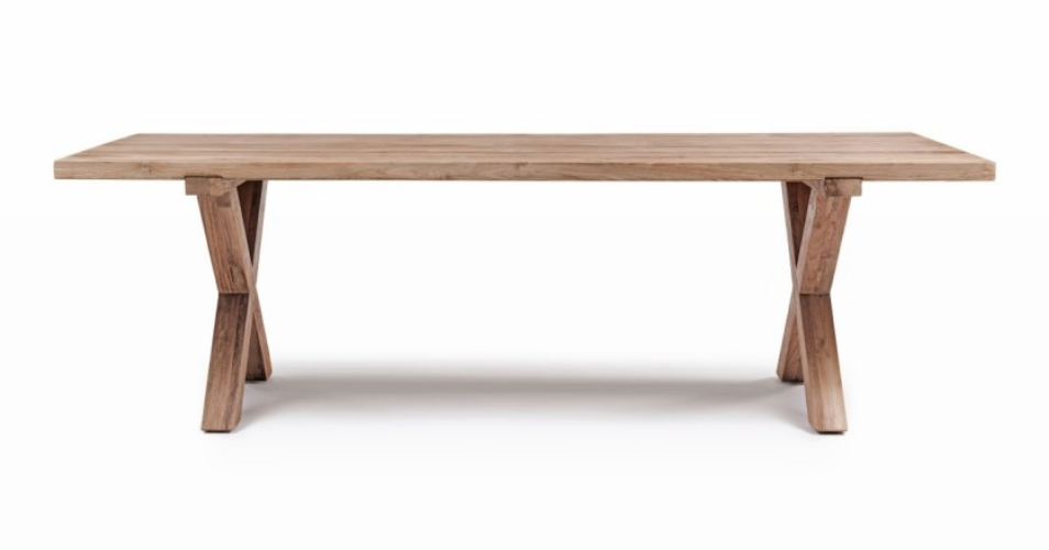 La table à manger Finca de Manufactori, détourée de son environnement, dévoile l’élégance de son design minimaliste. Son plateau rectangulaire, fabriqué en teck recyclé, présente des finitions impeccables qui accentuent la beauté naturelle et chaleureuse du bois. Le piètement en croix, à la fois stylisé et robuste, confère à la table un caractère distinctif tout en garantissant une stabilité parfaite.