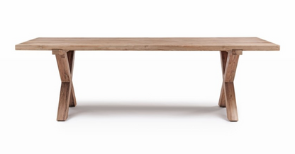 La table à manger Finca de Manufactori, détourée de son environnement, dévoile l’élégance de son design minimaliste. Son plateau rectangulaire, fabriqué en teck recyclé, présente des finitions impeccables qui accentuent la beauté naturelle et chaleureuse du bois. Le piètement en croix, à la fois stylisé et robuste, confère à la table un caractère distinctif tout en garantissant une stabilité parfaite.